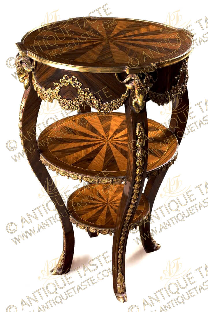 French Regence Early Louis XV style ormolu-mounted two tiers Étagère, Professionally inlaid with sunburst veneer inlays and ornamented with aged gilt ormolu mounts of knotted ribbons issuing swaging blossoming garlands, The fine side table with two tiers decorated with rich ormolu draped garlands of molded tassels, Raised by cabriole supports are headed with regal exquisite ormolu ram heads, ornamented with ormolu laurel garlands and terminating with ormolu hoof feet
